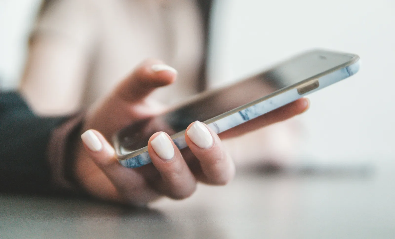 Eine Hand hält ein Smartphone und scrollt